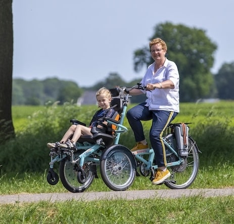 Mère et fille profitent d'une balade à vélo en Normandie, sur un chemin verdoyant, parfait pour des découvertes en famille.