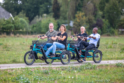 Quatre personnes sur des vélos à assistance, roulant sur une route champêtre en Normandie.