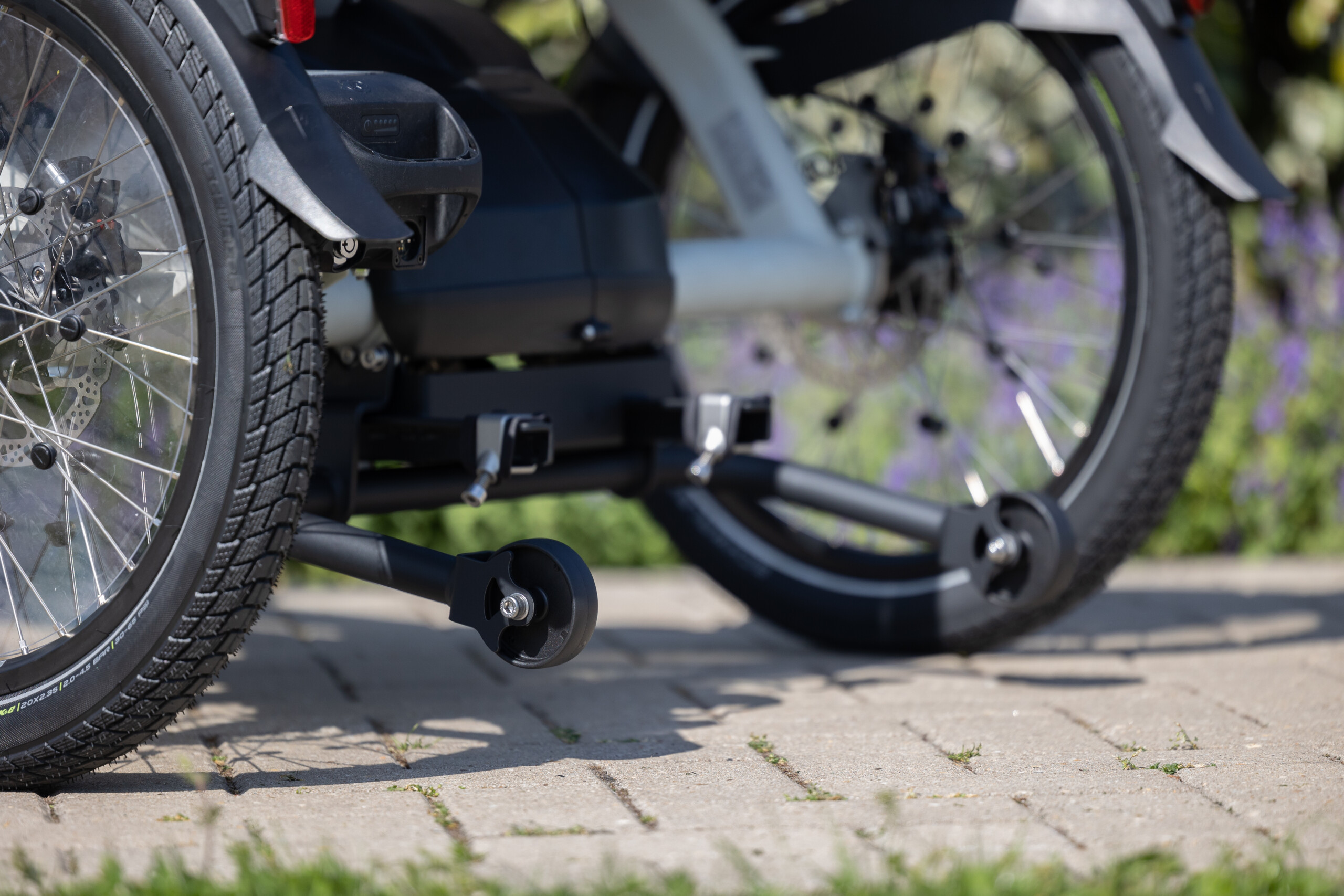 Détail d'un vélo électrique en location, prêt pour des balades en Normandie, sur un chemin pavé.