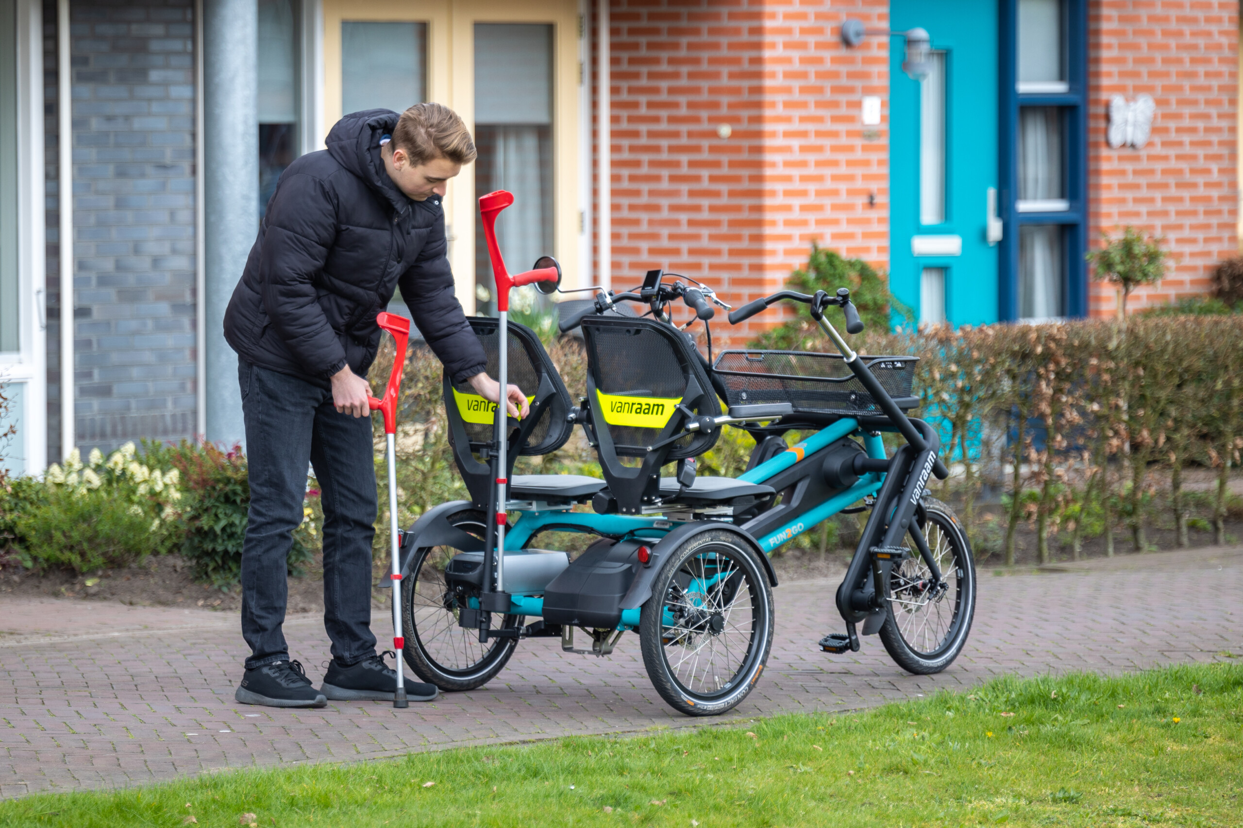 Un homme ajuste un vélo adapté avec deux sièges au bord d'un chemin, idéal pour des balades en famille ou entre amis.