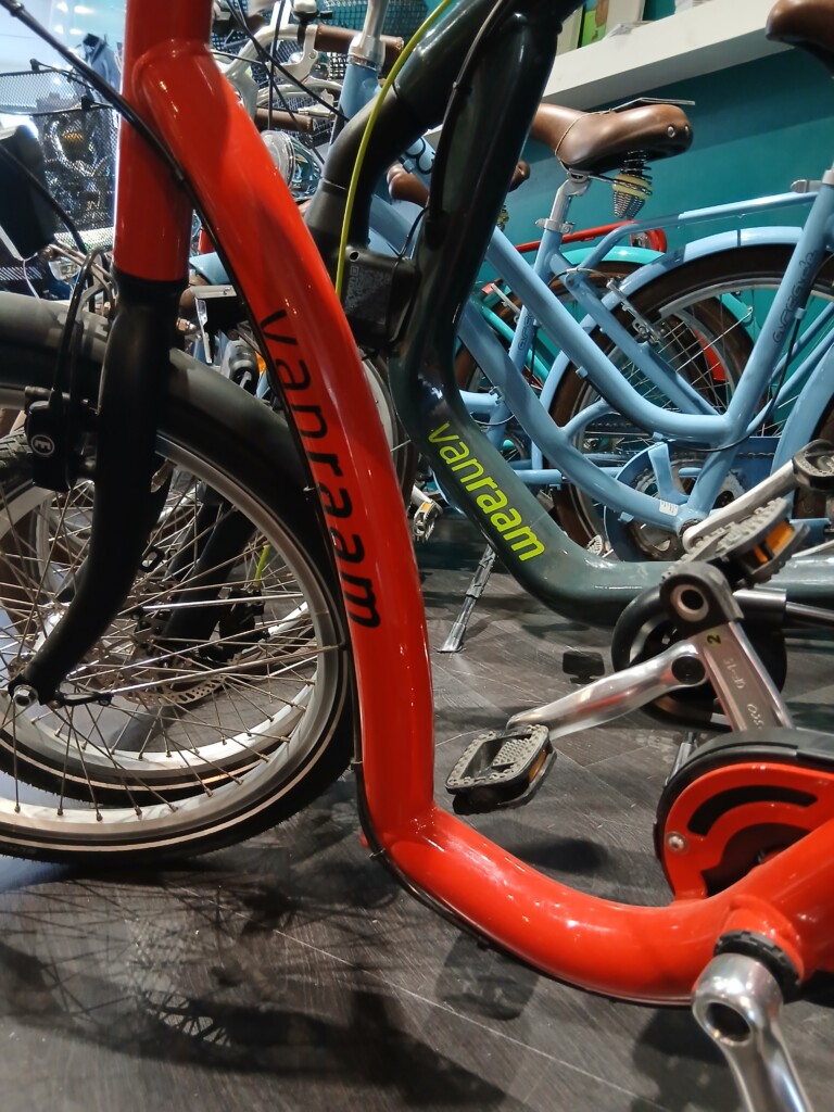 Vélos de location en Normandie, positionnés dans un magasin, avec des modèles colorés en arrière-plan.